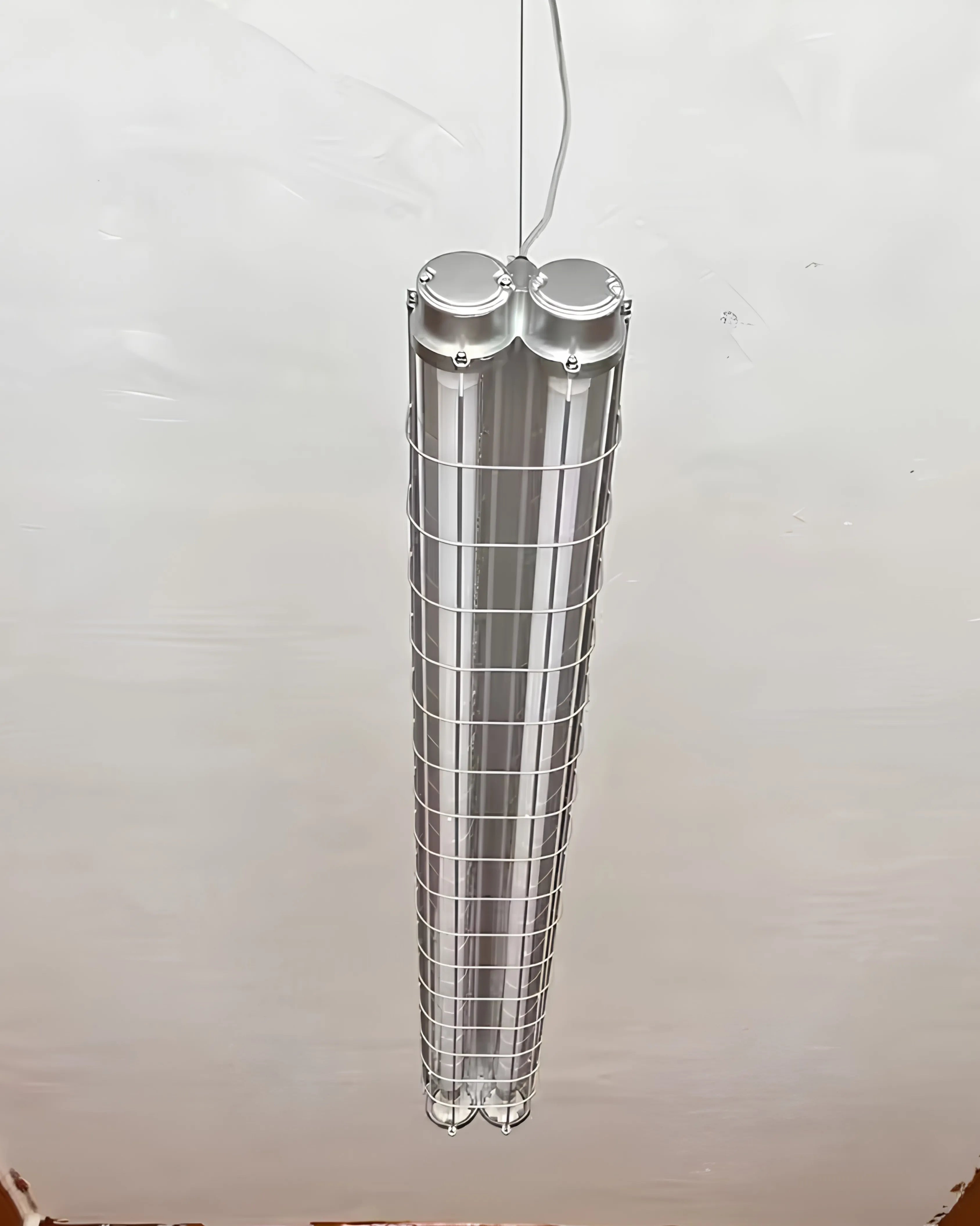 Suspension LED industrielle noire en tube long, éclairage linéaire parfait pour salle à manger, bureau ou cuisine moderne.