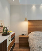 Suspension en métal mat avec forme fluide diffusant une lumière douce dans une chambre cosy